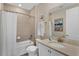 Relaxing bathroom features a tub and shower combo with white shower curtain, white vanity, and tile flooring at 2993 Caribbean Soul Dr, Kissimmee, FL 34747