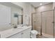 Bright bathroom features a walk-in shower with glass door and a white vanity with a large mirror and artwork at 2993 Caribbean Soul Dr, Kissimmee, FL 34747