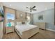 This bedroom features wood-look tile flooring, a ceiling fan, and a king bed with two nightstands at 2993 Caribbean Soul Dr, Kissimmee, FL 34747
