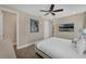 Well-lit bedroom features wood-look flooring, a ceiling fan and a mounted television for guest enjoyment at 2993 Caribbean Soul Dr, Kissimmee, FL 34747