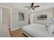 Bright bedroom features wood-look flooring, a ceiling fan and a mounted television for guest enjoyment at 2993 Caribbean Soul Dr, Kissimmee, FL 34747