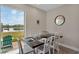 Charming dining area featuring a wooden table, white chairs, and a view of the lush green backyard and lake at 2993 Caribbean Soul Dr, Kissimmee, FL 34747