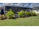 Screened-in patio with a well maintained lawn and lush tropical plantings at 301 Terranova Blvd, Winter Haven, FL 33884