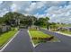 Community entrance with lush landscaping, sign and paved road at 301 Terranova Blvd, Winter Haven, FL 33884