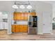 Bright kitchen with stainless steel refrigerator, wood cabinets, and wood floor at 301 Terranova Blvd, Winter Haven, FL 33884