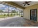 Covered patio with ceiling fan, tile flooring, and screened enclosure overlooking backyard at 301 Terranova Blvd, Winter Haven, FL 33884
