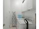 Functional laundry room with washer, dryer, ironing board, and overhead cabinets at 3111 Sun Lake Ct # B, Kissimmee, FL 34747