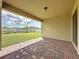 Covered back patio features a brick floor and leads to a well-maintained backyard at 3193 Crispin Cir, Harmony, FL 34773