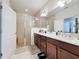 Bathroom featuring a double vanity, shower, and neutral tile at 3193 Crispin Cir, Harmony, FL 34773