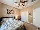 A cozy bedroom featuring a ceiling fan, closet, and a comfortable bed with floral bedding at 3193 Crispin Cir, Harmony, FL 34773