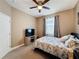 Bedroom with ceiling fan, window, TV on a rustic media console, and neutral decor at 3193 Crispin Cir, Harmony, FL 34773