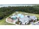 Aerial view of community pool with lounge chairs, playground, splash pad, and clubhouse at 3193 Crispin Cir, Harmony, FL 34773