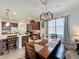 Cozy dining area with modern light fixture, adjacent to a kitchen with stainless appliances at 3193 Crispin Cir, Harmony, FL 34773