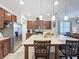 Well-lit kitchen with a central island, stainless steel refrigerator, and extensive cabinet space at 3193 Crispin Cir, Harmony, FL 34773