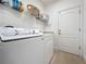 Bright laundry room with a modern washer and dryer, shelving and storage space at 3193 Crispin Cir, Harmony, FL 34773