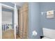 Upstairs bathroom featuring a shower with a beige curtain, toilet, and blue walls at 3214 Herons Point Cir, Kissimmee, FL 34741