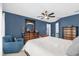 Charming bedroom features a blue accent wall, ceiling fan, and furnishings at 3214 Herons Point Cir, Kissimmee, FL 34741