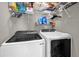 Laundry room featuring a modern washer and dryer set with shelving for supplies at 3214 Herons Point Cir, Kissimmee, FL 34741