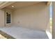 Neutral back porch features concrete flooring, a light, and a back door at 328 Lily Ln, Davenport, FL 33837
