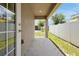 Back porch with concrete flooring, a small patch of grass, and a view of the yard and neighboring homes at 328 Lily Ln, Davenport, FL 33837