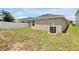Grassy backyard featuring a fenced-in perimeter and a neutral-colored home at 328 Lily Ln, Davenport, FL 33837