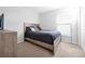 Cozy bedroom features a bed with neutral-colored pillows, carpet flooring, and a large window at 328 Lily Ln, Davenport, FL 33837