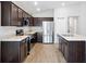 Modern kitchen with stainless steel appliances, island, and dark cabinets at 328 Lily Ln, Davenport, FL 33837