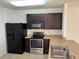Well-equipped kitchen with dark cabinetry, stainless steel appliances, and ample counter space at 359 Arbor Lakes Dr, Davenport, FL 33896