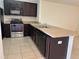 Functional kitchen with stainless steel appliances, dark wood cabinets, and a breakfast bar at 359 Arbor Lakes Dr, Davenport, FL 33896