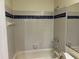 Bathroom featuring white tiled walls and a blue accent stripe and a bath tub at 4085 Dijon Dr # 4085J, Orlando, FL 32808