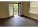 Bedroom featuring a private balcony entrance and neutral walls, complemented by elegant wood-look flooring at 4085 Dijon Dr # 4085J, Orlando, FL 32808
