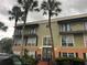 Inviting condo building featuring palm trees and multiple balconies perfect for enjoying the outdoors at 4085 Dijon Dr # 4085J, Orlando, FL 32808