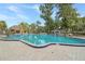 Community pool with ample deck space, surrounded by trees and a gazebo at 4085 Dijon Dr # 4085J, Orlando, FL 32808