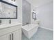 Modern bathroom with double sink vanity, soaking tub, and decorative tile accent wall at 41 Orchid Ct, Kissimmee, FL 34759