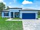 Beautiful single-story home with a well-manicured lawn, paved driveway, and attractive blue garage door and shutters at 41 Orchid Ct, Kissimmee, FL 34759