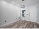 Bright foyer featuring wood-look floors, a textured accent wall, a modern light fixture, and a white front door at 41 Orchid Ct, Kissimmee, FL 34759