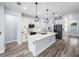 Open-concept kitchen featuring white cabinets, a center island with pendant lights, and stainless steel appliances at 41 Orchid Ct, Kissimmee, FL 34759