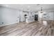 Open-concept living space featuring wood-look floors, a kitchen island with pendant lighting, and ample natural light at 41 Orchid Ct, Kissimmee, FL 34759