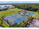 Aerial view showcasing the tennis courts, playground, and surrounding landscape at 4244 Windchime Ln, Lakeland, FL 33811
