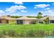 Home's backyard features lush green grass that leads to a serene lake view at 4244 Windchime Ln, Lakeland, FL 33811