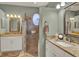 Bright bathroom with dual vanities, granite countertops, decorative mirrors, and tiled walk-in shower at 4244 Windchime Ln, Lakeland, FL 33811