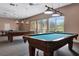 Well-lit billiards room with two pool tables and large windows overlooking the grounds at 4244 Windchime Ln, Lakeland, FL 33811