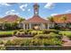 Beautifully landscaped entrance to the clubhouse with a bell tower and vibrant flower beds at 4244 Windchime Ln, Lakeland, FL 33811