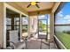 Screened-in lanai with beautiful lake view, ceiling fan and comfortable seating at 4244 Windchime Ln, Lakeland, FL 33811