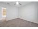 Bedroom with carpet flooring, ceiling fan, and view into bathroom with tiled shower at 4505 Hummingbird Ln, Haines City, FL 33844