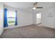 Spacious bedroom with carpet flooring, ceiling fan, and a window with blue curtains at 4505 Hummingbird Ln, Haines City, FL 33844