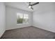 Bright bedroom features neutral carpet, fan, and a window providing natural light at 4505 Hummingbird Ln, Haines City, FL 33844