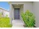 Inviting covered front door, featuring colorful plants, and gray exterior at 4505 Hummingbird Ln, Haines City, FL 33844