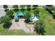 Aerial view of a playground featuring shade structures, multiple play areas, and mature shade trees at 4505 Hummingbird Ln, Haines City, FL 33844