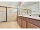 Bathroom featuring double vanity, granite counters, and a large tiled shower with sliding glass doors at 4918 Wildwood Pointe Rd, Winter Garden, FL 34787